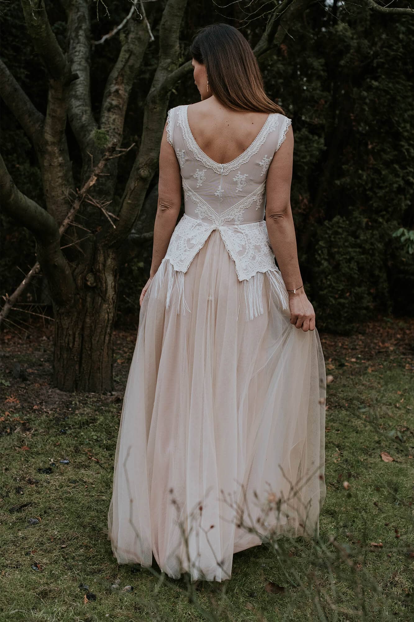 suknia ślubna z koronkowym wykończeniem, długim tiulowym dołem i rozcięciem z tyłu