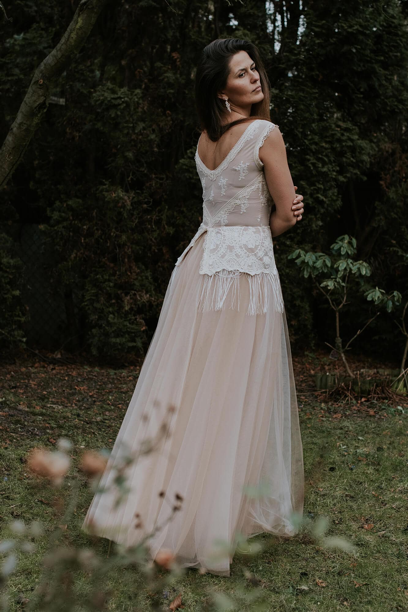 suknia ślubna z koronkowym bodicem i tiulowym dołem, widoczna z tyłu w plenerze