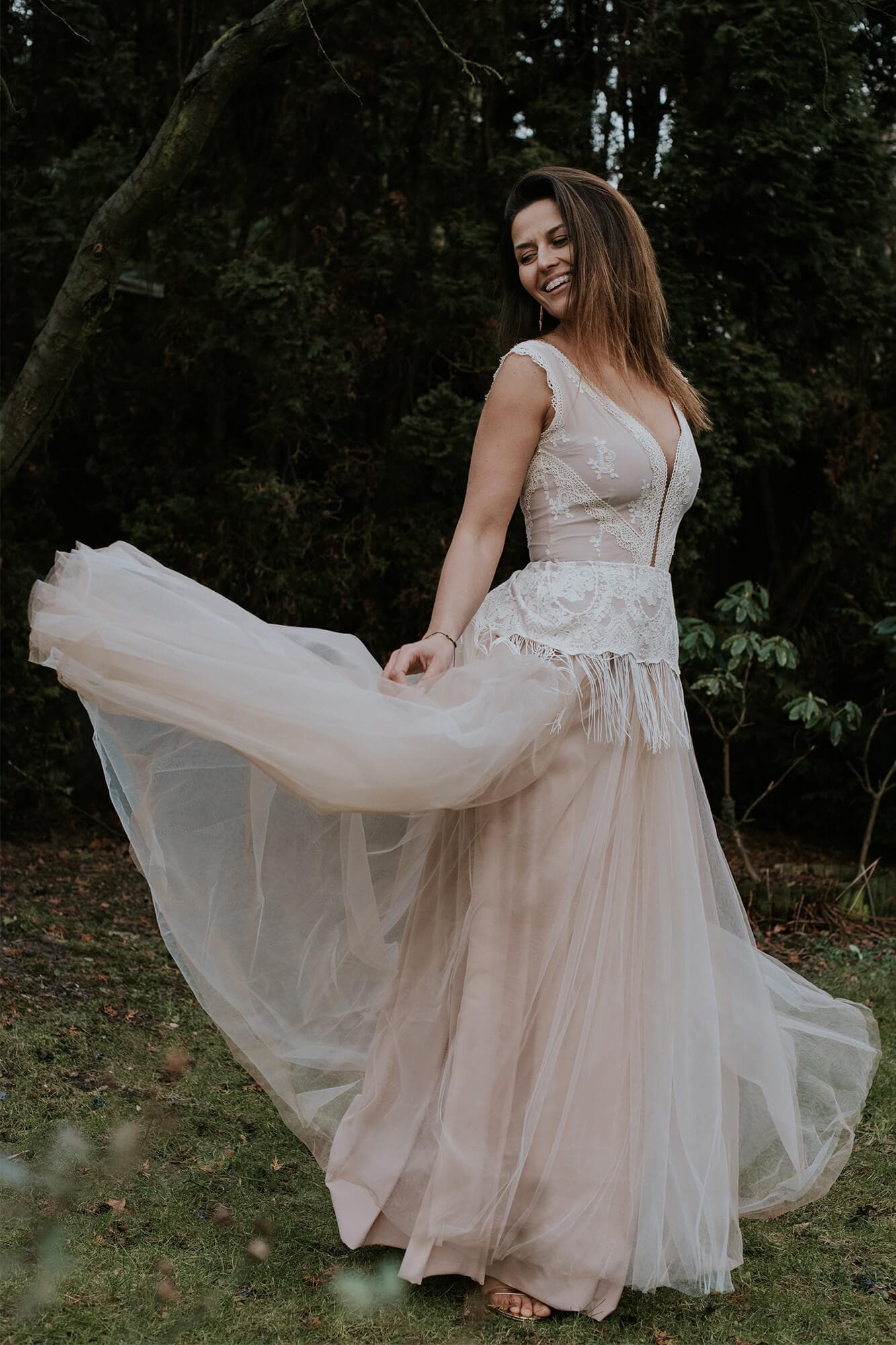 Suknia ślubna w jasnym kolorze z koronkowym gorsetem i zwiewnym dołem.