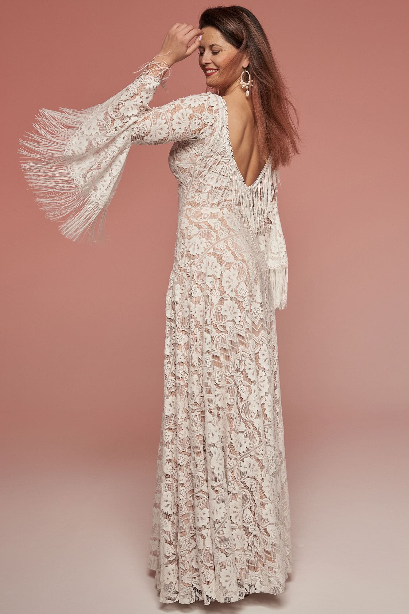 suknia ślubna z długimi rękawami, delikatnym wzorem i głębokim dekoltem z tyłu