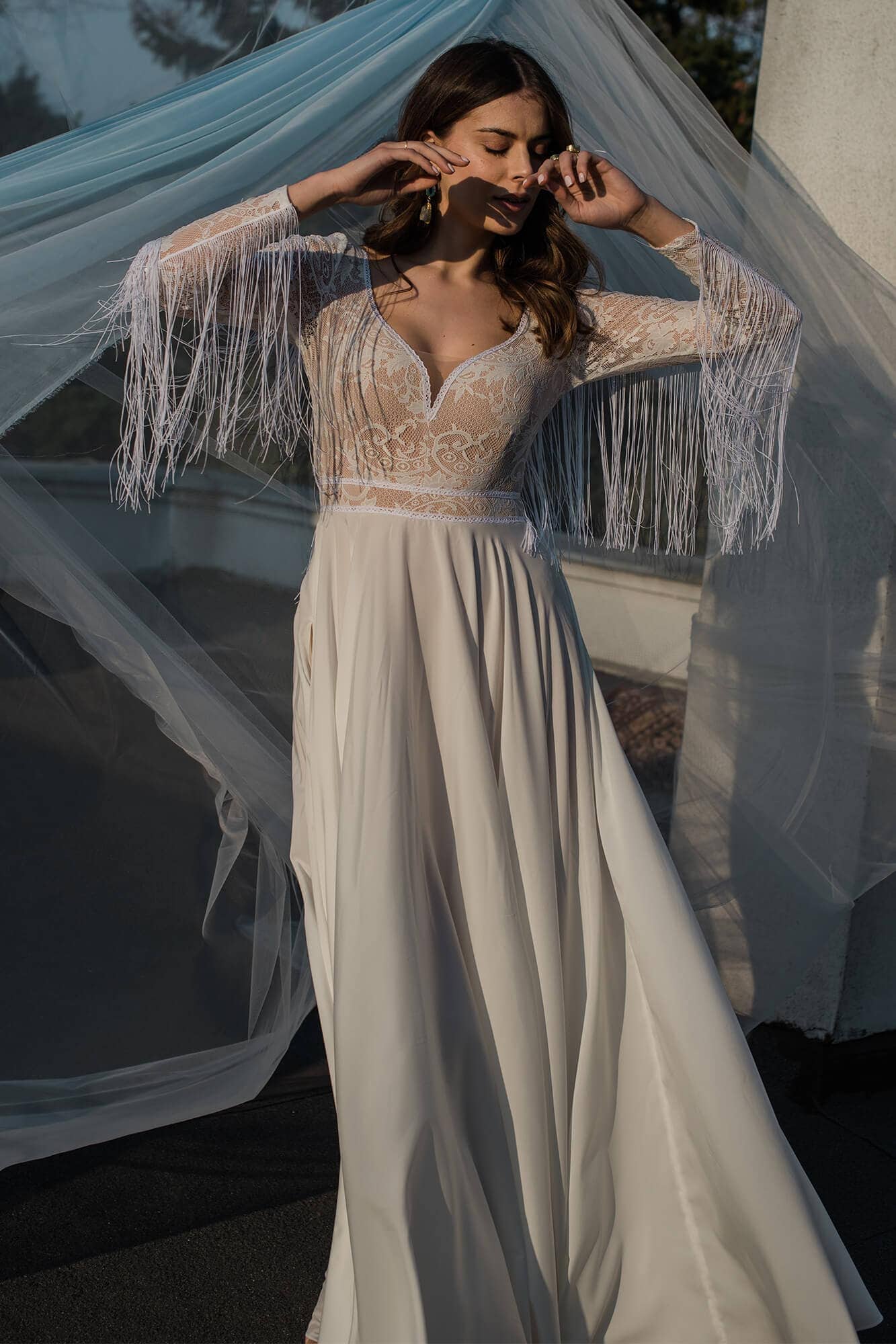 suknia ślubna z koronkowym górnym materiałem i długimi frędzlami na rękawach