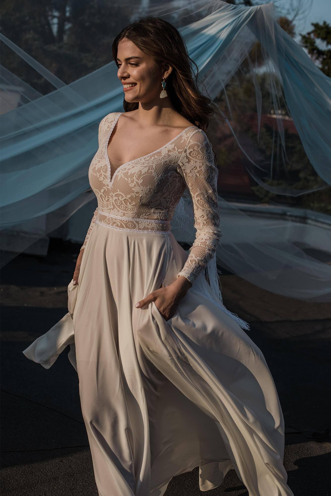 suknia ślubna z koronkowymi rękawami i rozkloszowanym dołem, w kolorze jasnym.