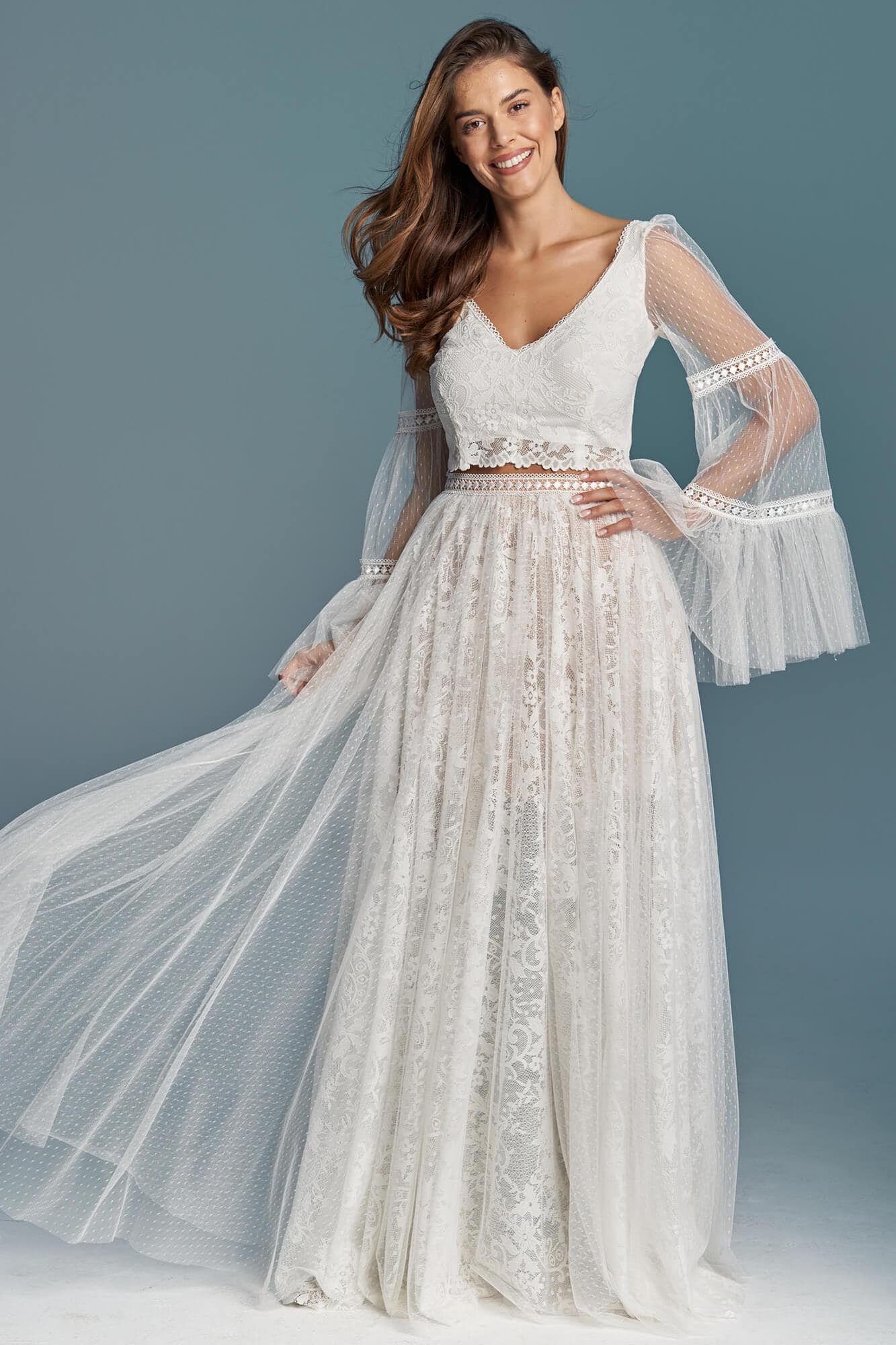 suknia ślubna z koronkowym górnym elementem i długimi, przezroczystymi rękawami