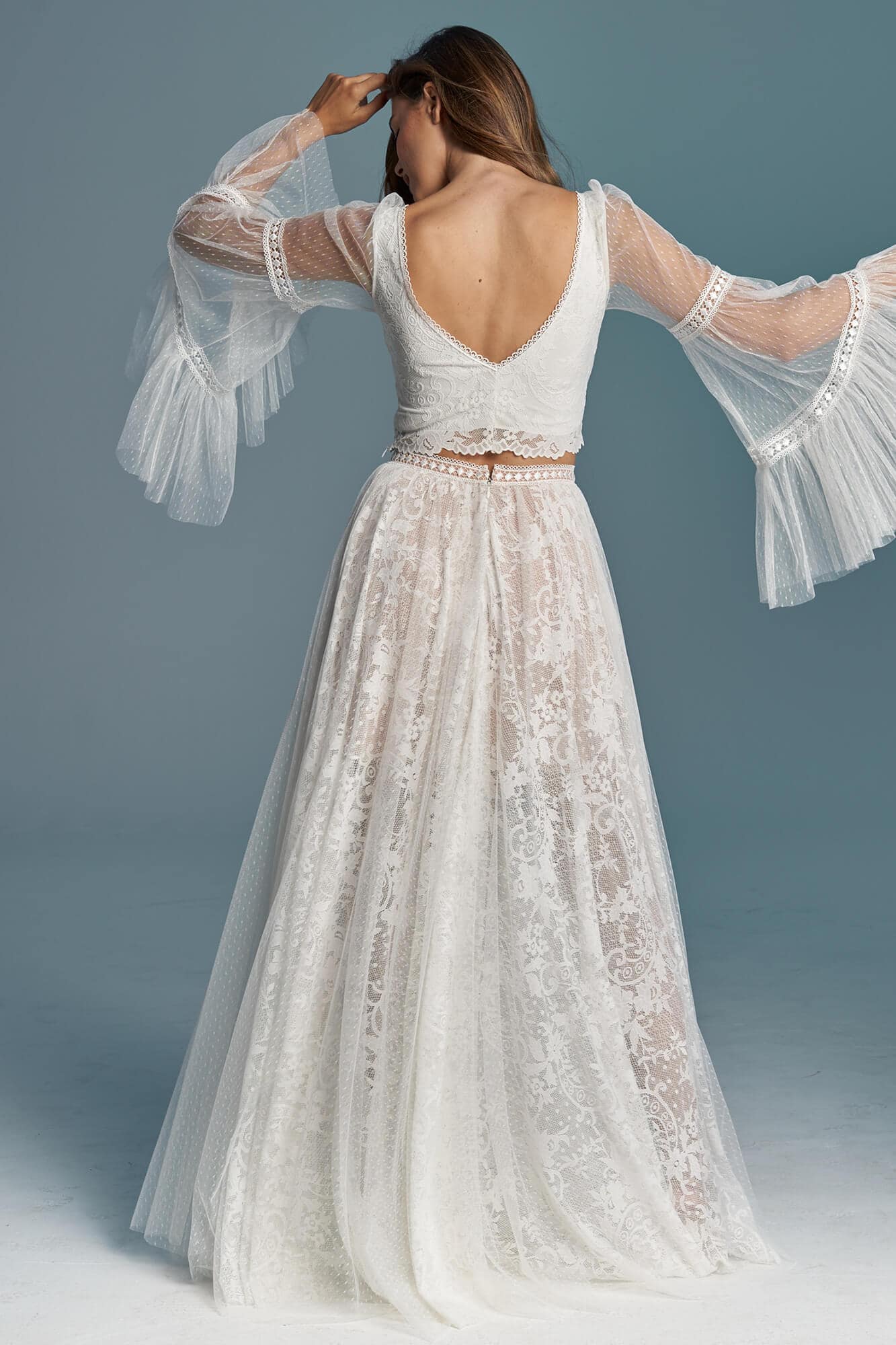suknia ślubna z koronkowym górnym elementem i długimi, przezroczystymi rękawami