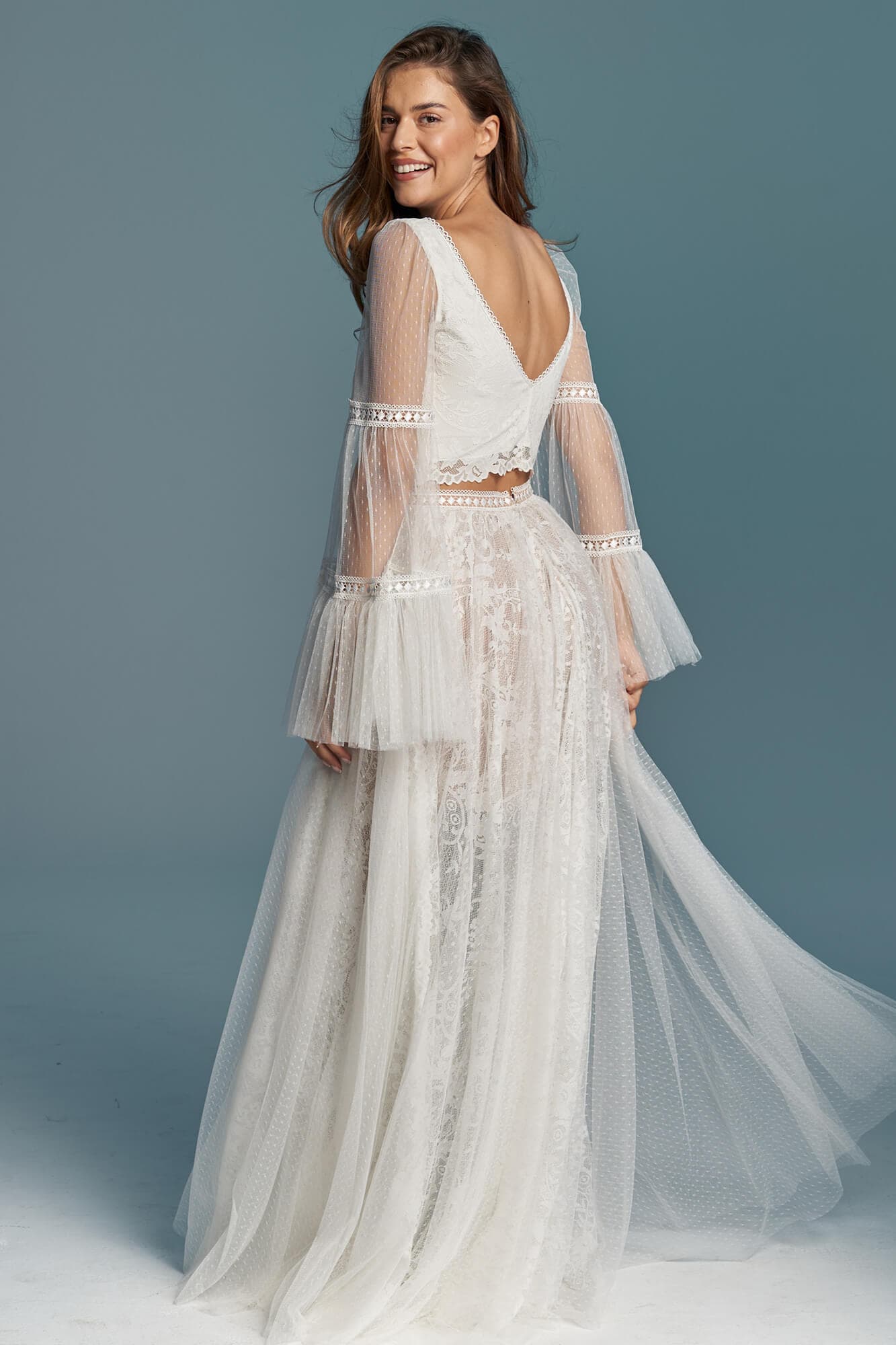 suknia ślubna z długimi, przezroczystymi rękawami i koronkowym wykończeniem, widoczna z tyłu