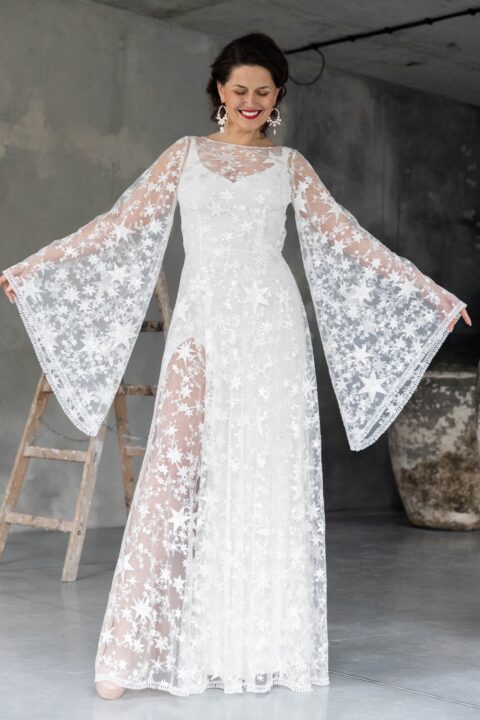 suknia ślubna z długimi, szerokimi rękawami, ozdobiona gwiazdkowym wzorem na białym tle