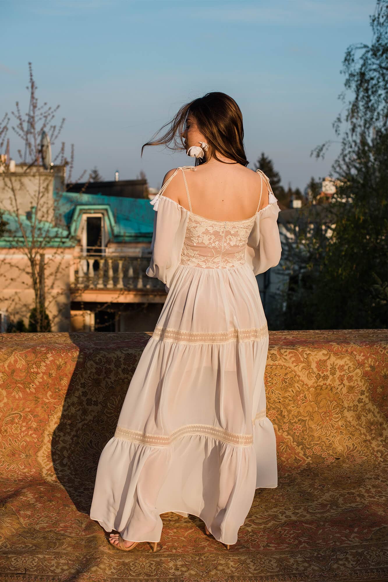 suknia ślubna z koronkowym gorsetem i długimi, luźnymi rękawami, widok z tyłu