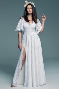 suknia ślubna z koronkowym wzorem, długim rękawem i rozcięciem na nodze