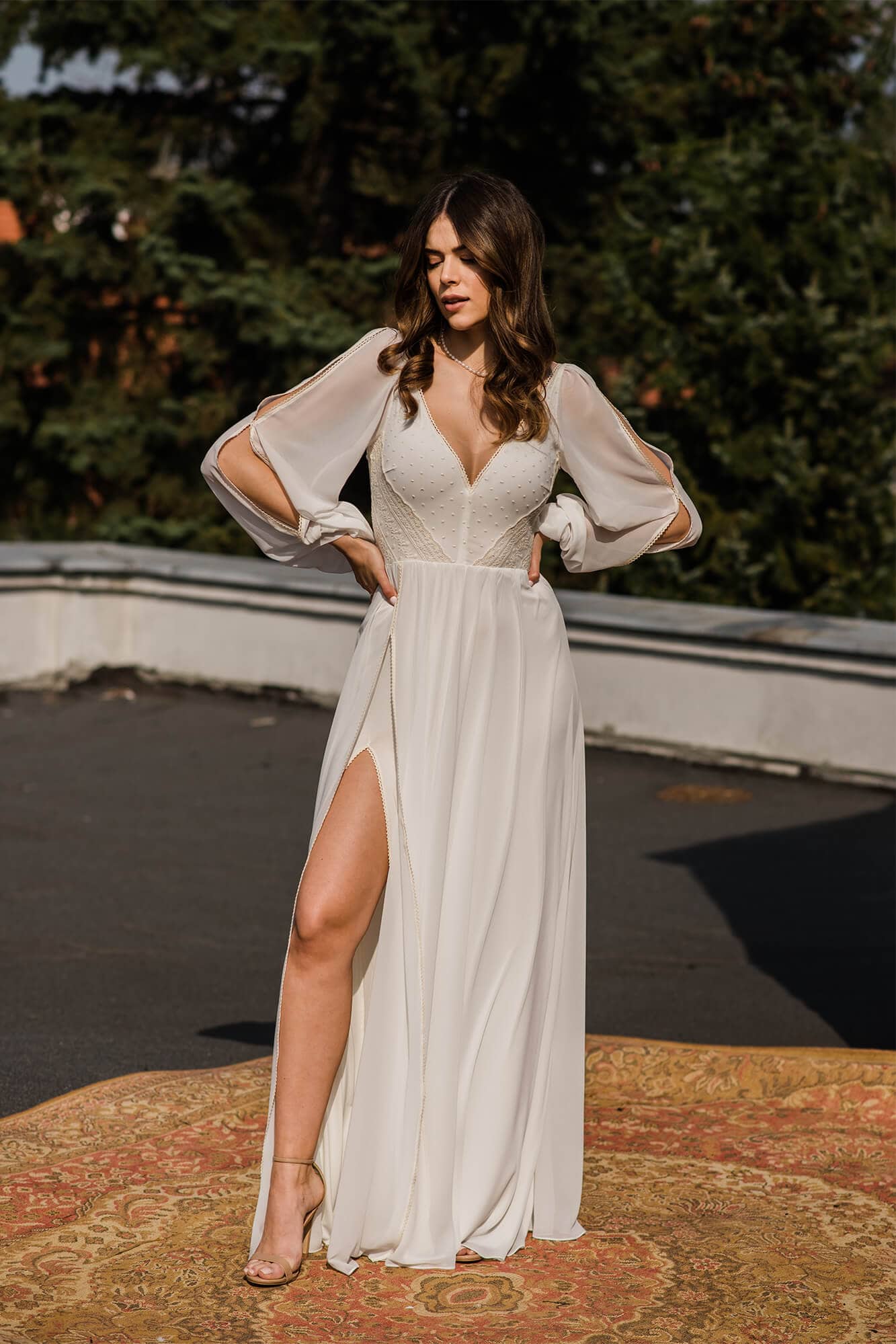 suknia ślubna z długimi, przezroczystymi rękawami i dekoltem w kształcie litery V, z rozcięciem na nodze