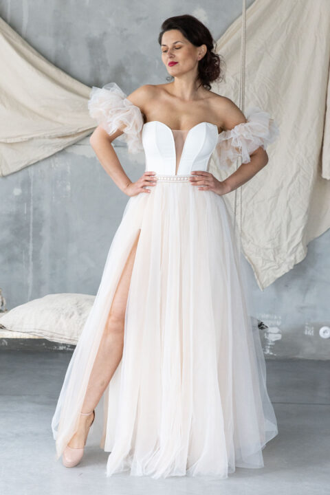 suknia ślubna z dekoltem w serek, odkrytymi ramionami i tiulowymi rękawami, z wysokim rozcięciem.