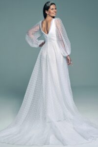suknia ślubna z długimi, przezroczystymi rękawami i falbaną na dole, w kolorze białym.