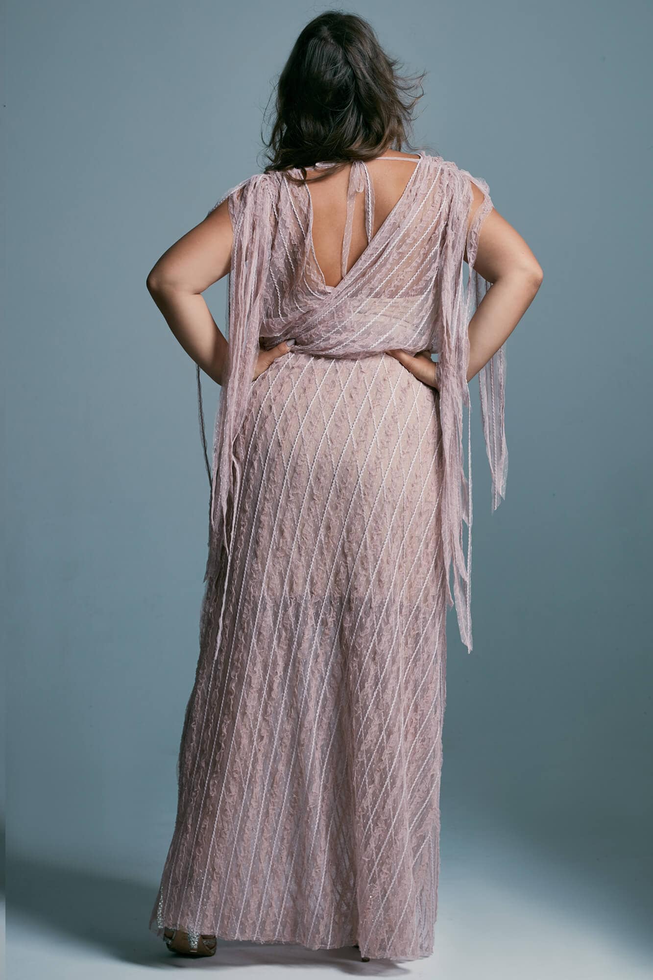 suknia w kolorze różowym z odkrytymi plecami i długimi frędzlami na ramionach