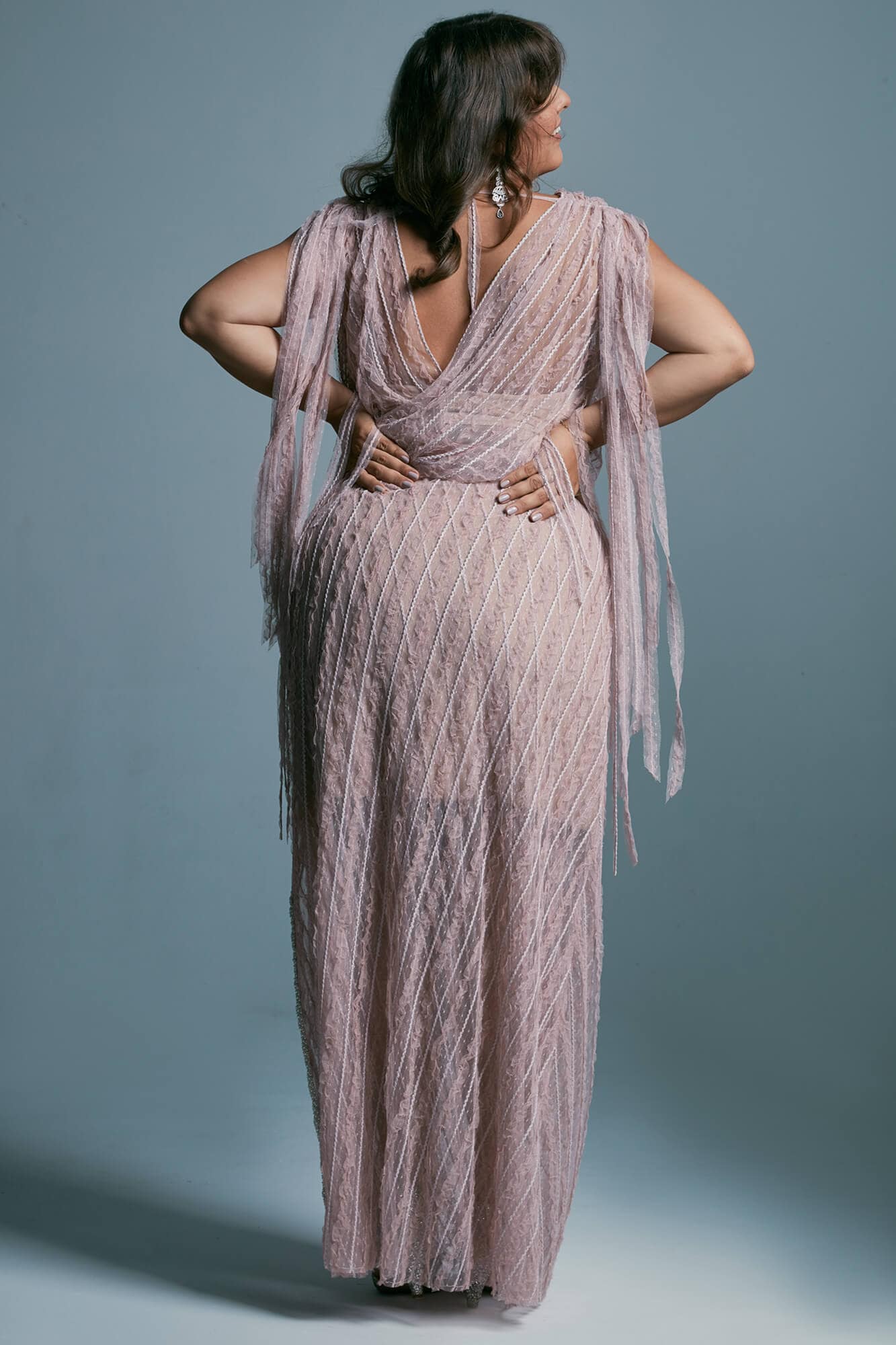 suknia w kolorze różowym z długimi frędzlami, modelka w pozycji stojącej