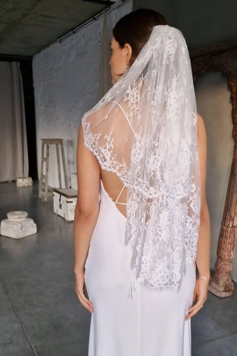suknia ślubna z koronkowym zdobieniem na plecach i długim welonem