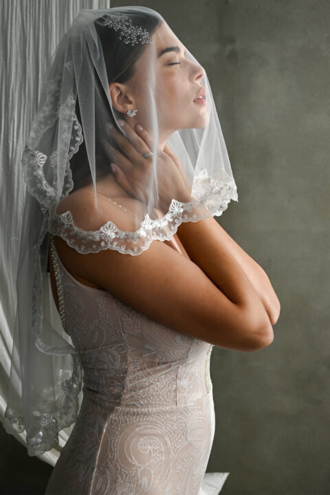 suknia ślubna z koronkowymi detalami i welonem na głowie kobiety