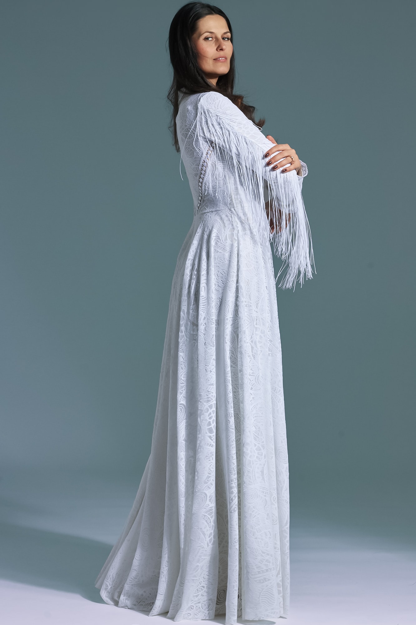 suknia ślubna z długim rękawem, ozdobiona frędzlami, w kolorze białym.