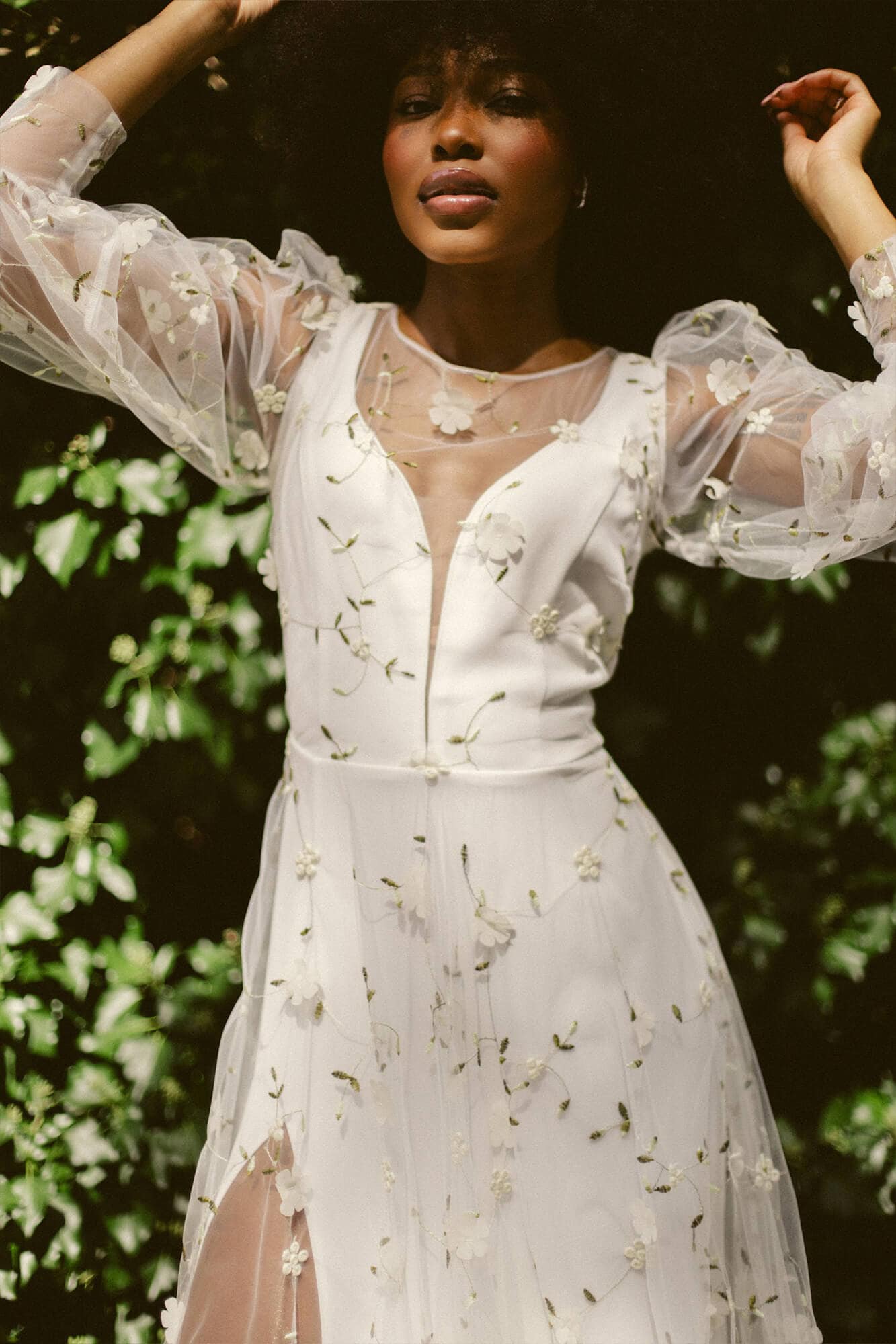 suknia ślubna z koronkowymi rękawami i dekoltem w kształcie litery V, z kwiatowymi wzorami na tkaninie