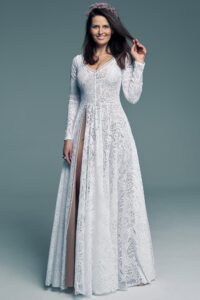 suknia ślubna z długimi rękawami, koronkowym wzorem i rozcięciem na boku, modelka z kwiatami we włosach