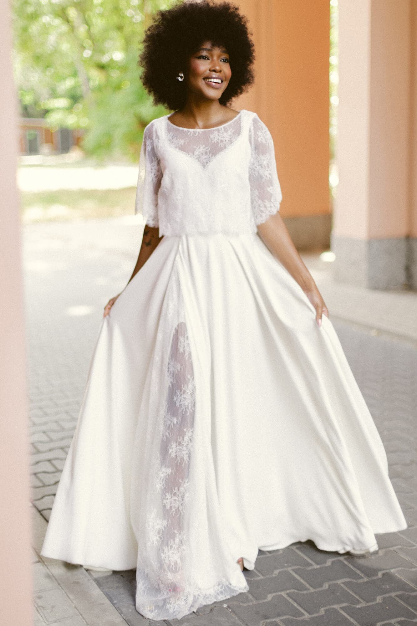 suknia ślubna z długim rękawem, w kolorze białym, z koronkowym wykończeniem na górze.