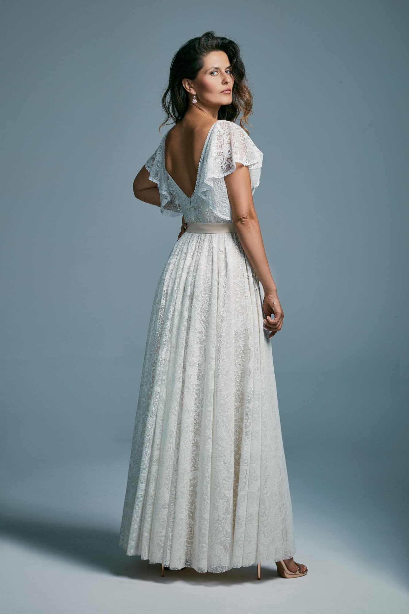 suknia ślubna z odkrytymi plecami i krótkimi rękawami, wykonana z jasnego materiału