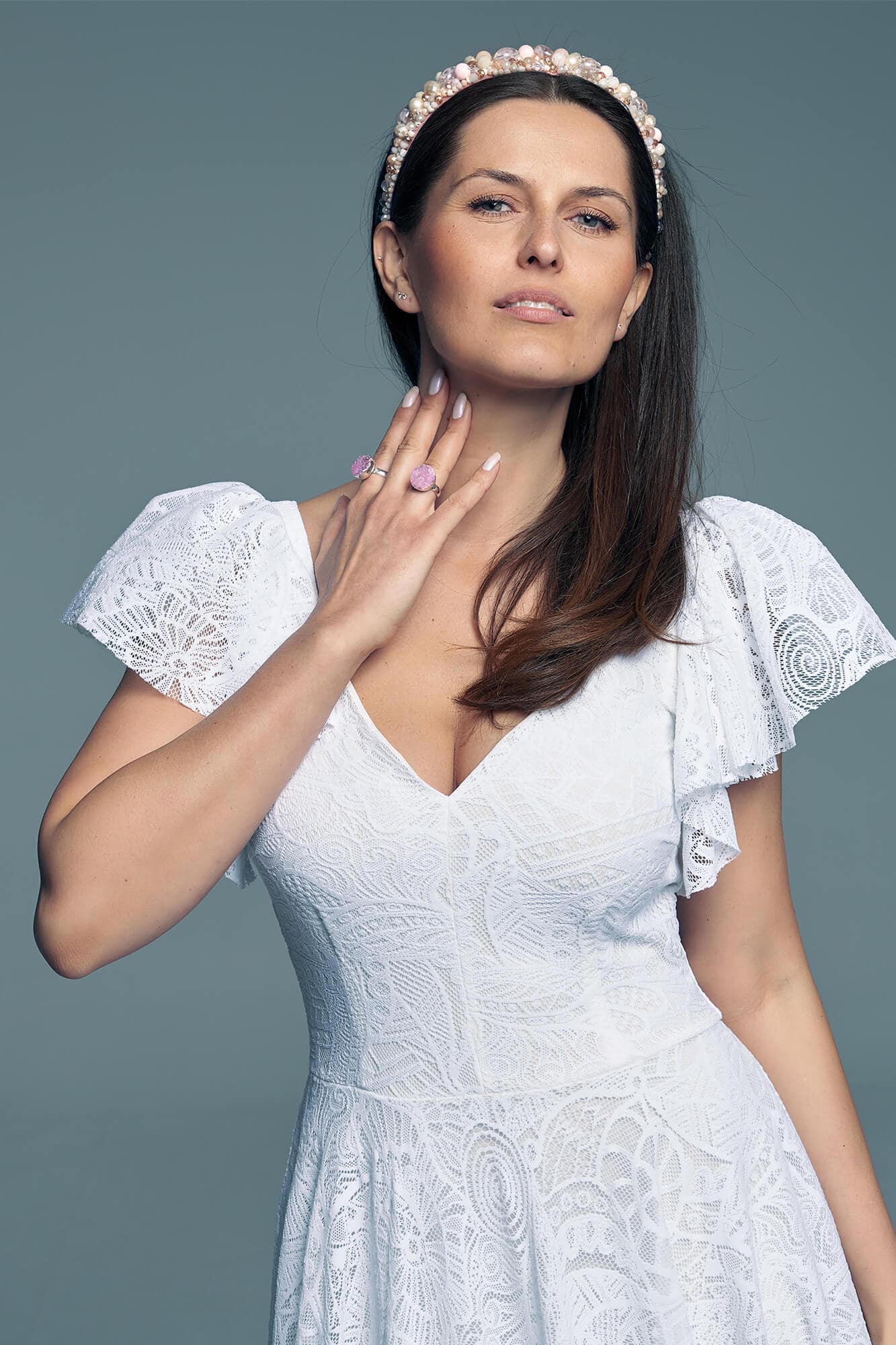 suknia ślubna z dekoltem w serek i falbaniastymi rękawami, modelka z biżuterią na szyi