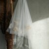 zawieszony woal ślubny na wieszaku, wykonany z przezroczystego materiału