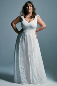 suknia ślubna z dekoltem w serek i koronkowymi ramiączkami, w kolorze białym.