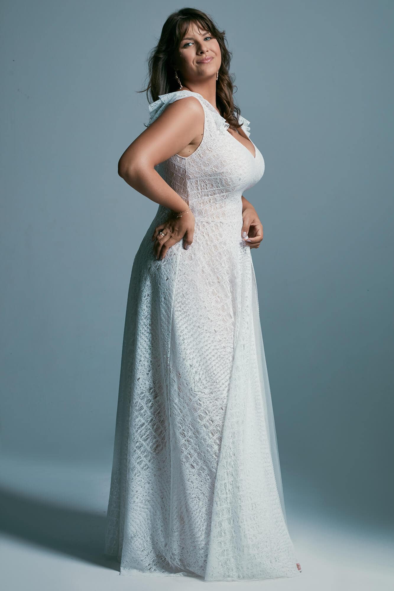 suknia ślubna z koronkowym wzorem, z odkrytymi ramionami i falbanami na ramiączkach